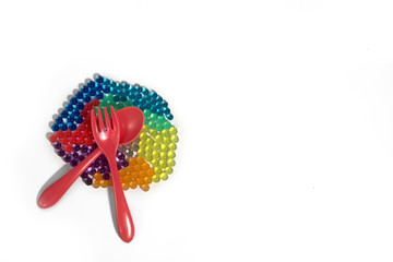 Colored caviar with a fork and spoon on a white background. View from above.