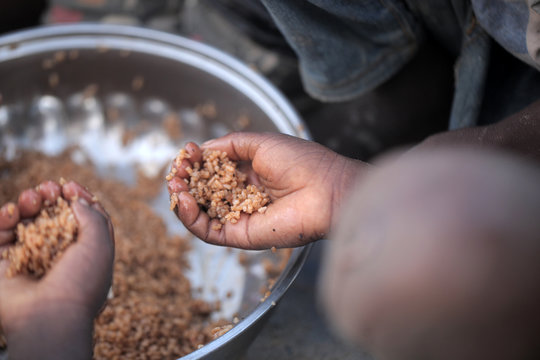 kids eating brown rice and fish in Africa - closeup