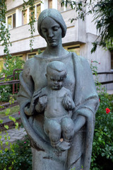 Fototapeta na wymiar Virgin Mary with baby Jesus statue in the garden of the Blind Center Saint Raphael in Bolzano, Italy