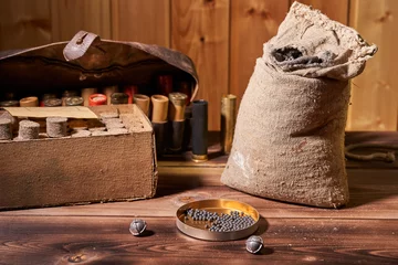 Rolgordijnen Hunting equipment for making cartridges on a wooden table © Vitalii Makarov