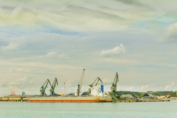 Fototapeta na wymiar Water landscape with ships and cranes in the navy repair shipyard under the dramatic sky