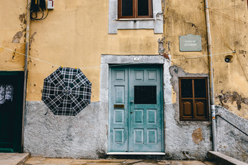 Ein Regenschirm hängt vor einem Haus in einer kleinen Gasse in Porto