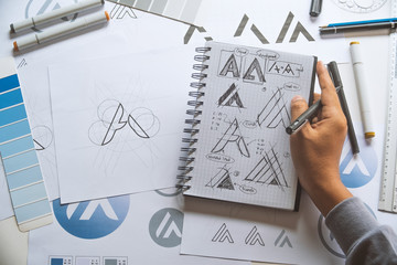 Graphic designer development process drawing sketch design creative Ideas draft Logo product trademark label brand artwork. Graphic designer studio Concept.