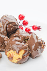 Delicious profiteroles with cream and chocolate glaze closeup