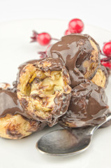 Delicious profiteroles with cream and chocolate glaze closeup