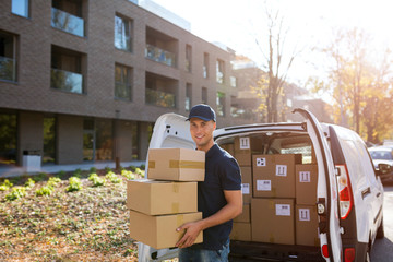 Delivery man standing in front of his van