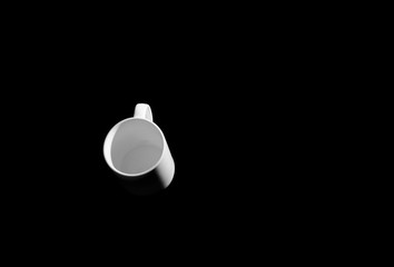 White cup in black space.