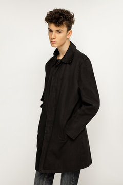 Handsome young man wearing black long trench coat