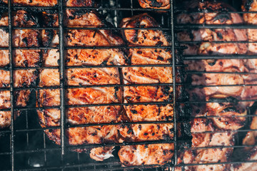 pork meat is fried on the grill for barbecue on the coals