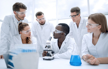 Fototapeta premium Focused and serious female and male chemists in lab coats and sa