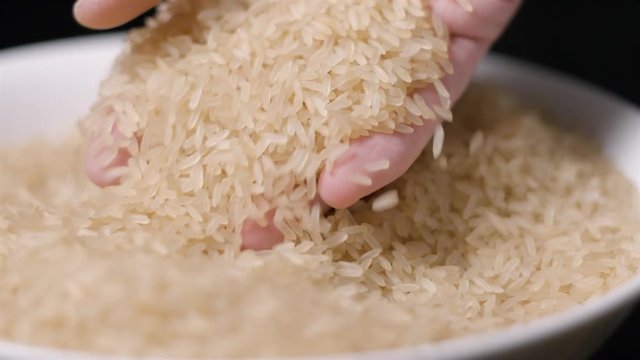 Rice falling in hand slow motion
