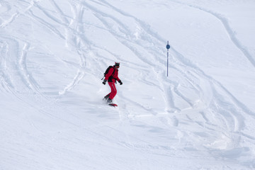 Fototapeta na wymiar Snowboarder descends on snowy off-piste slope