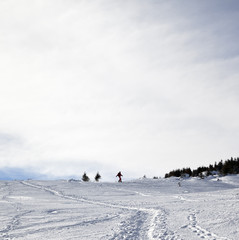 Silhouette of downhill snowboarder on snowy off-piste slope in winter
