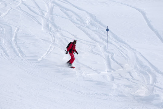 Snowboarder descends on snowy off-piste slope