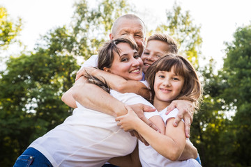 Obraz premium Happy family in the Park. Mom, dad, son and daughter during a walk in a summer