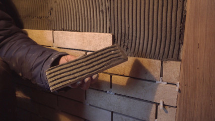 Construction Worker Installing Tiles On A Wall