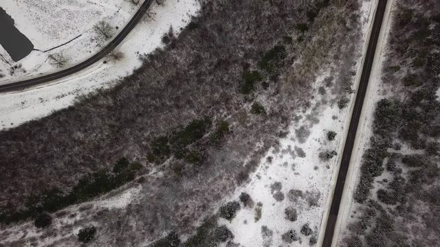 Aerial drone view of road in idyllic winter landscape. Street running through the nature from a birds eye view