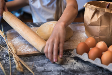 Knead the dough with wheat on dark background