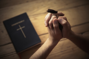 Man hand cross with Bible