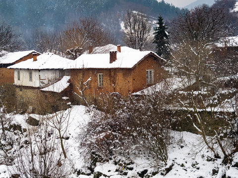 Picturesque snowy rural view to old riverbank houses at the Bulgarian village of Debnevo, Central-North Bulgaria
