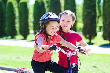 Obraz premium fun children ride a bike. Smiling kids summer vacation