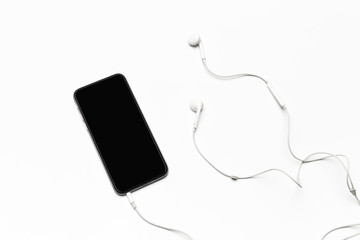 Mobile phone with white earphones isolated on white