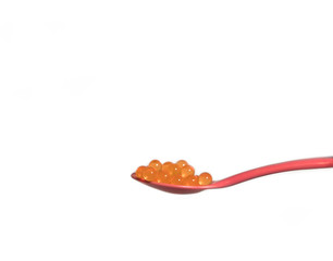 Red caviar on a pink spoon, white background.
