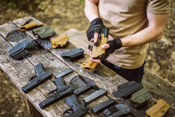 guy in the woods tests his weapons for shooting sports