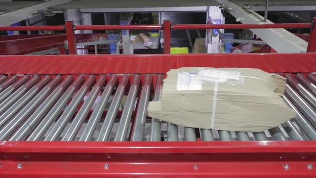 Boxes and Packages at Conveyor Belt in Distribution Warehouse