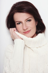 Portrait of attractive smiling mature woman in white pullover