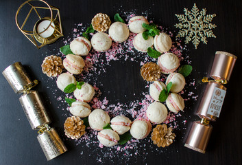 Fototapeta na wymiar Sweet Christmas Wreath with Macarons, Candy Cane and Crackers