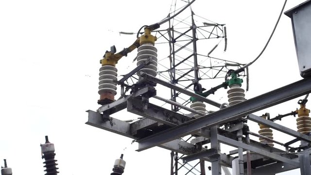 Electrical substation equipment: electricity transmission line, earthing switch. Frame. Earthing switch and a power line on sky background.