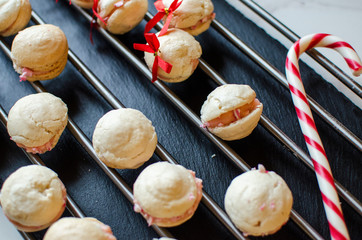 French Macarons with Red Ribbon and Candy Cane on a Rack