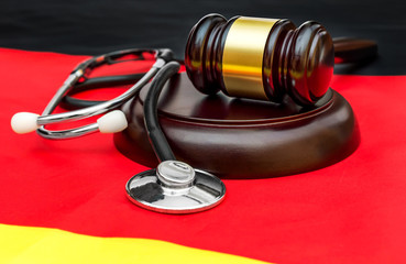 Gavel with stethoscope on German flag. Medical law.