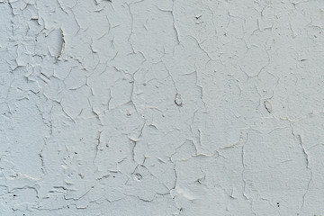 Natural background. Wall with a shabby and peeling paint, crack and plaster.  gray and white