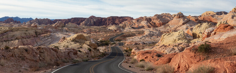 Scenic panoramic view on the road in the desert during a cloudy and sunny day. Taken in Valley of Fire State Park, Nevada, United States.