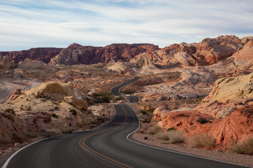 Scenic view on the road in the desert during a cloudy and sunny day. Taken in Valley of Fire State Park, Nevada, United States.