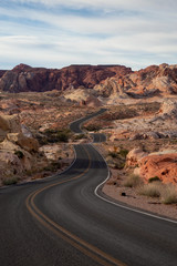 Scenic view on the road in the desert during a cloudy and sunny day. Taken in Valley of Fire State Park, Nevada, United States.