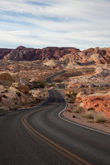 Scenic view on the road in the desert during a cloudy and sunny day. Taken in Valley of Fire State Park, Nevada, United States.