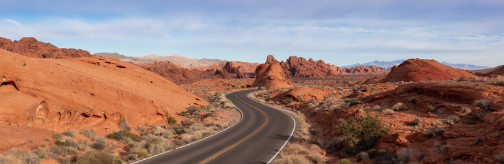 Scenic panoramic view on the road in the desert during a cloudy and sunny day. Taken in Valley of...