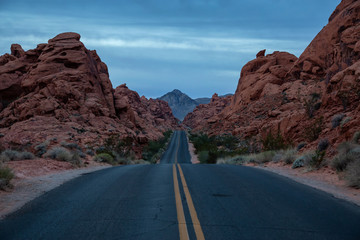 Scenic view on the road in the desert during a cloudy sunrise. Taken in Valley of Fire State Park, Nevada, United States.