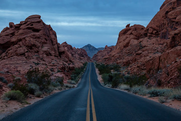 Scenic view on the road in the desert during a cloudy sunrise. Taken in Valley of Fire State Park, Nevada, United States.