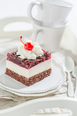Obraz na płótnie Canvas Closeup of sweet jelly cherry cake with cream and cherries