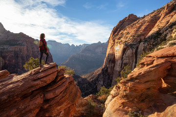 Adventurous Girl at the edge of a cliff is looking at a beautiful landscape view in the Canyon...