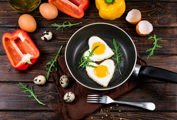 fried eggs on a skillet on a wooden background
