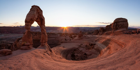Beautiful panoramic landscape of the unique sandstone rock formation in the desert during a sunny sunset. Taken in Arches National Park, Moab, Utah, United States.