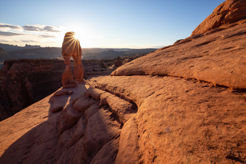 Beautiful landscape of the unique sandstone rock formation in the desert during a sunny sunset. Taken in Arches National Park, Moab, Utah, United States.