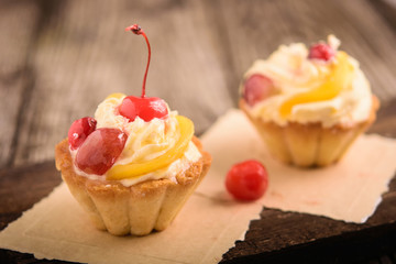 Small fruitcakes  with cream filling and cherry  for Christmas dinner.