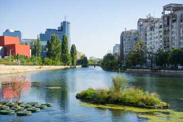 Dambovita river in downtown Bucharest; residential and office buildings on its shoreline, Romania