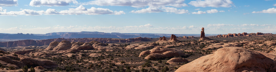 Panoramic Landscape view of beautiful red rock canyon formations during a vibrant sunny day. Taken in Arches National Park, located near Moab, Utah, United States.